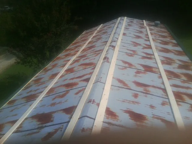 Rusted metal roof panels with new wood purlins before replacement — Storm Damage Roof Repair in Clifton Park by Roofing Brothers