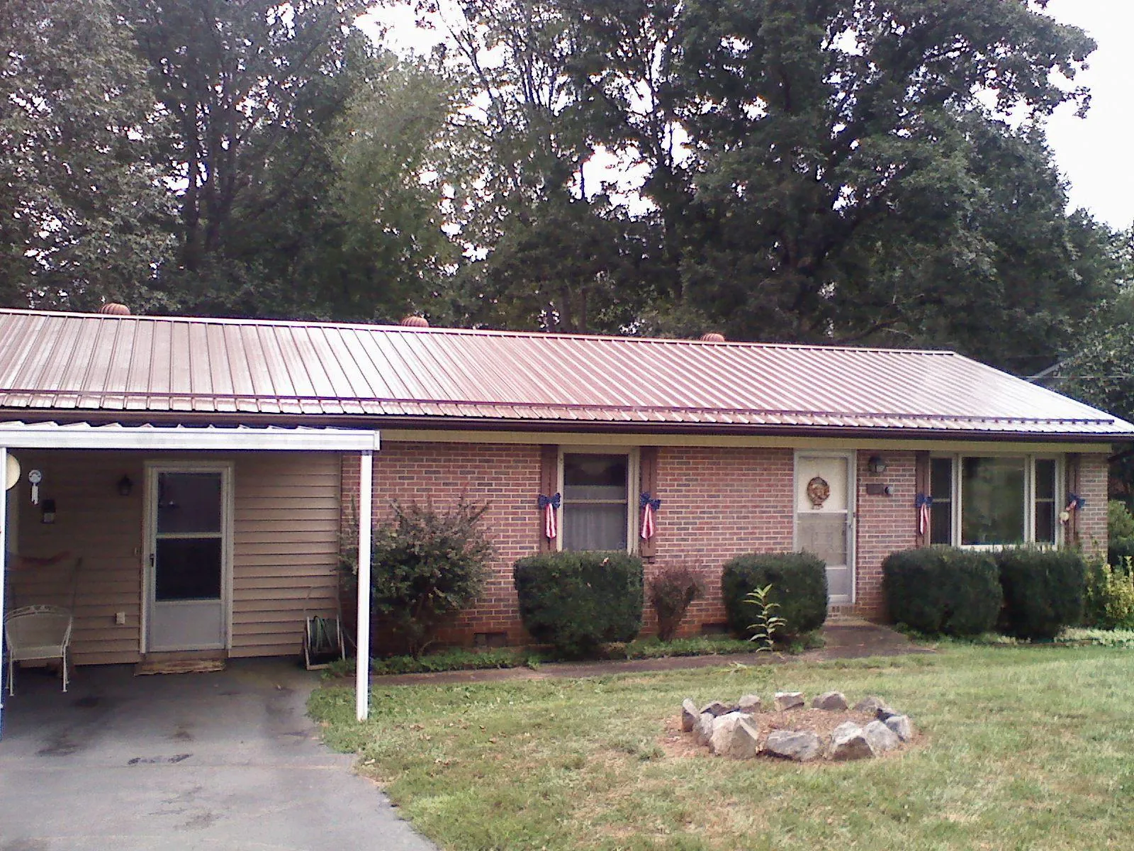Bronze metal roof and carport on a brick ranch home — Roof Repair work by our crew in Clifton Park